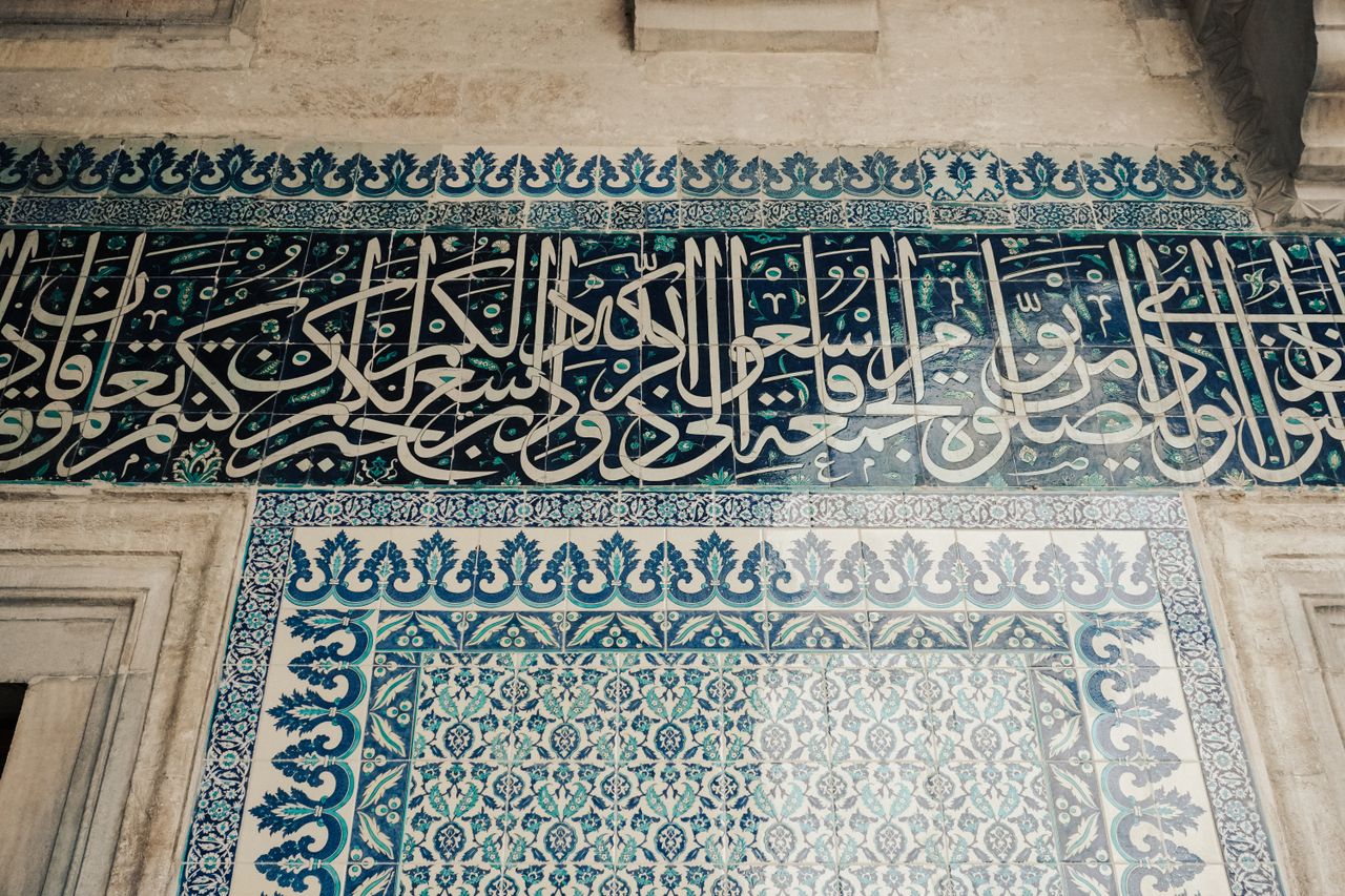 Beautiful Islamic tile adorned with intricate Arabic calligraphy and geometric patterns.
